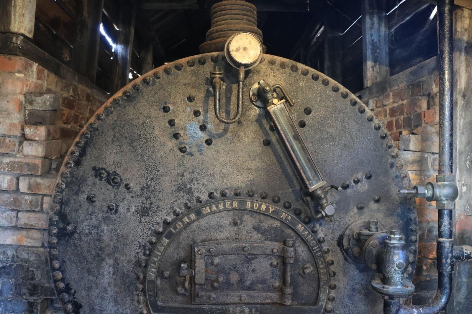 Bagian depan boiler pipa api dengan pengukur tekanan, salah satu titik yang rutin diperiksa di ruang boiler